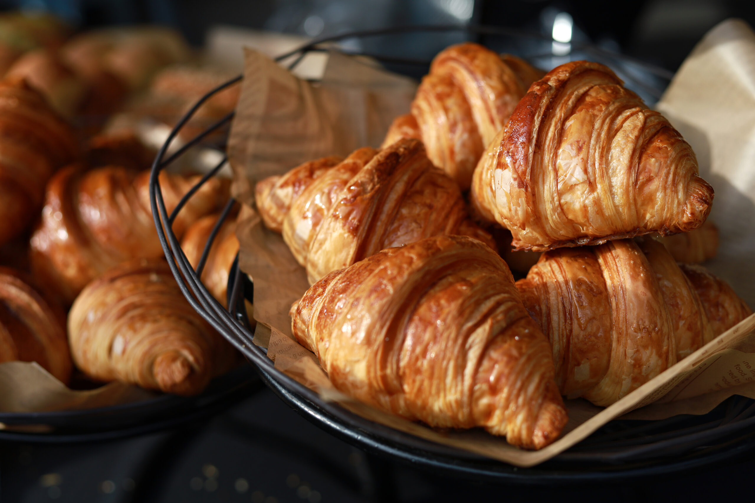 Freshly baked croissants display on a tray in a bakery shop