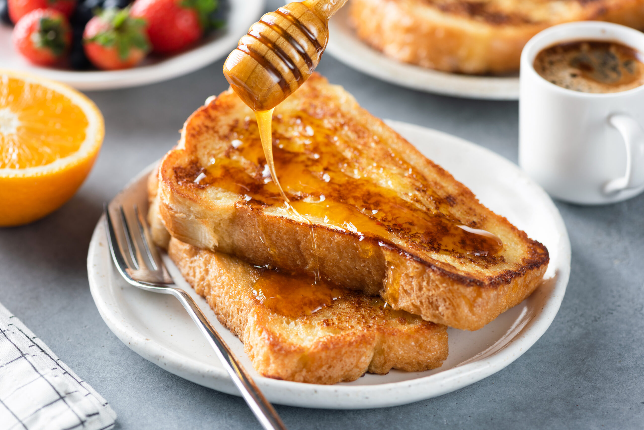 Pouring honey on french toast. Sweet breakfast food