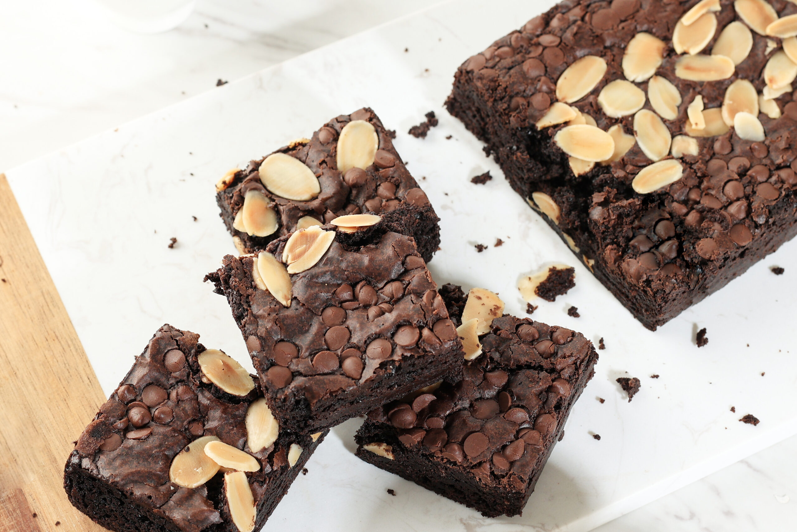 Sliced Brownies with Chocolate Chips and Almond. on White Table