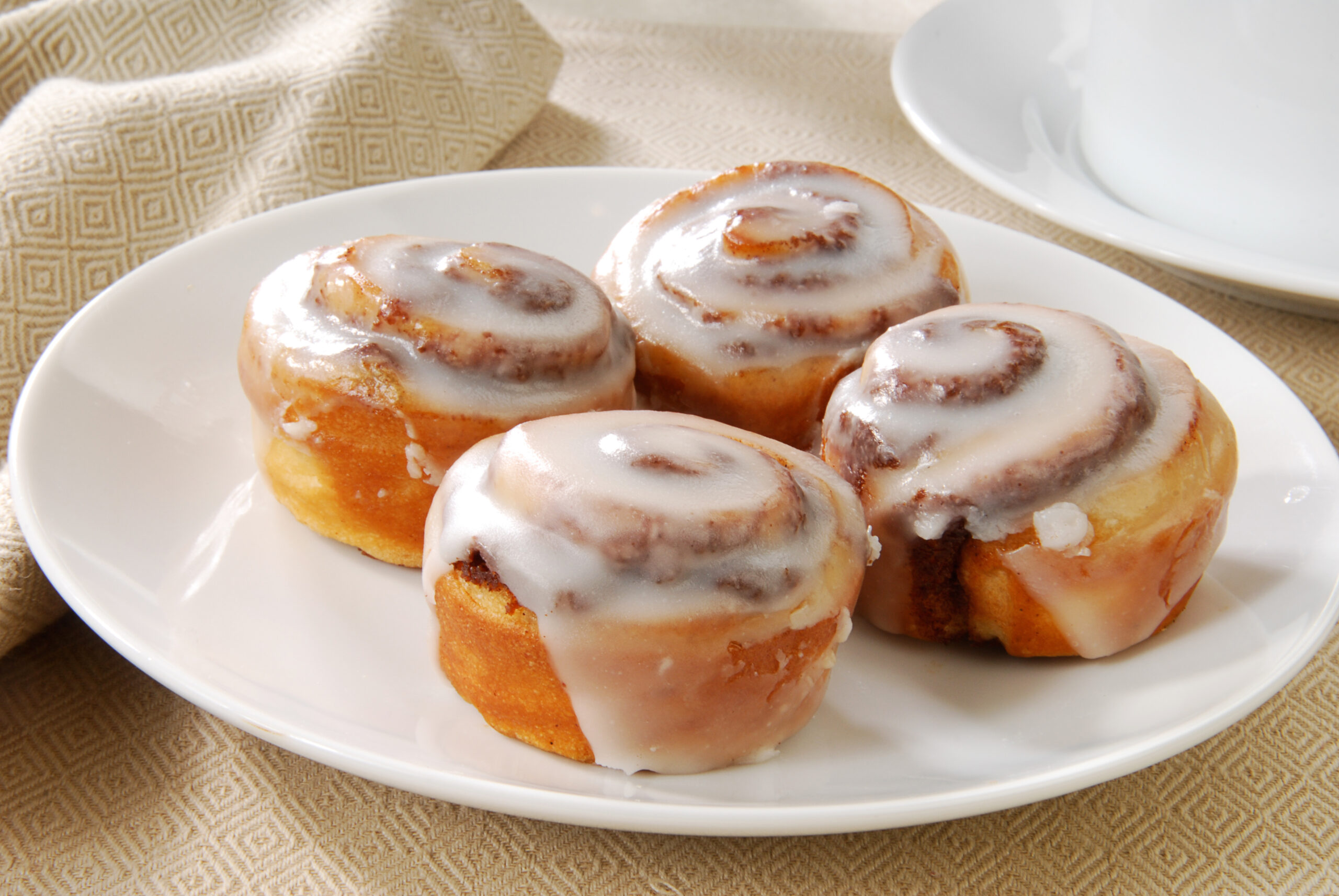 A close up photo of a plate of cinnamon rolls