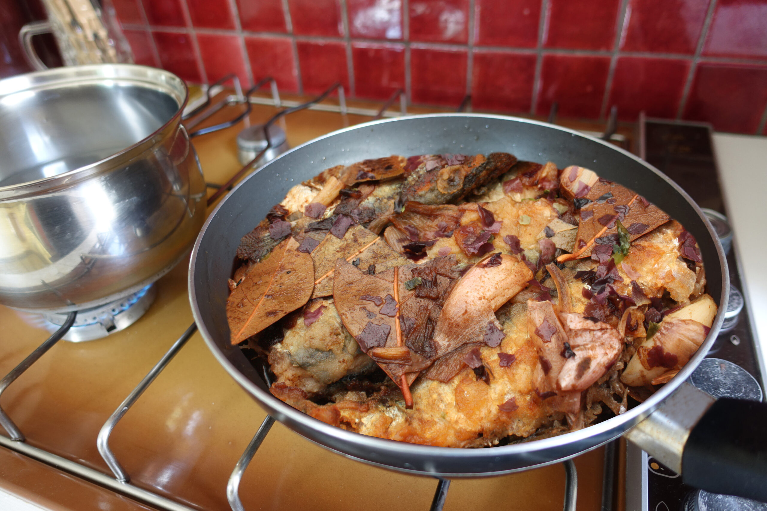 Escabeche of sardines being cooked with herbs Spanish cuisine