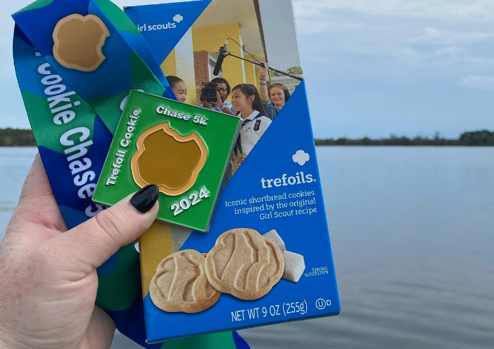 Trefoil Girl Scout Cookies branded for a fundraising race next to a lake or body of water, Instagram