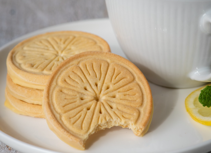 Lemonade Girl Scout Cookies on a white plate with a cup of tea, Facebook