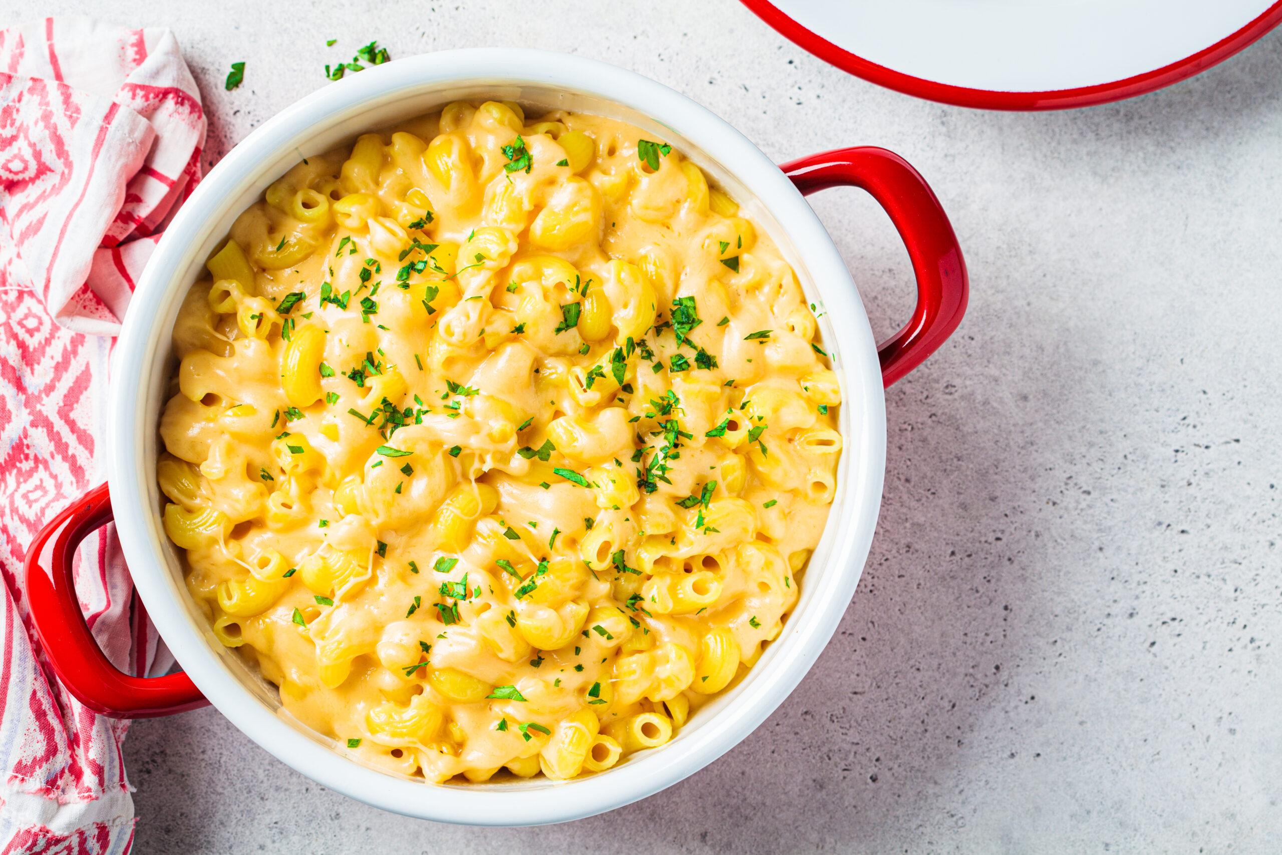 Mac and cheese in red pot, top view. Traditional American food.