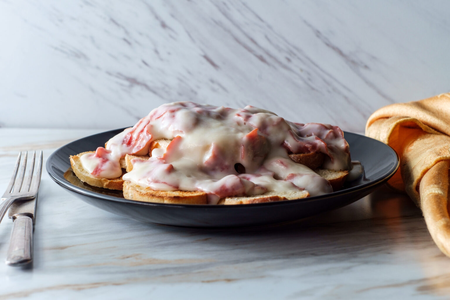 Creamed and chipped beef on sliced toast on marble kitchen table also known as S.O.S.