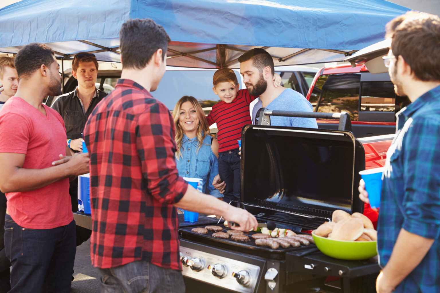 Group Of Sports Fans Tailgating In Stadium Car Park