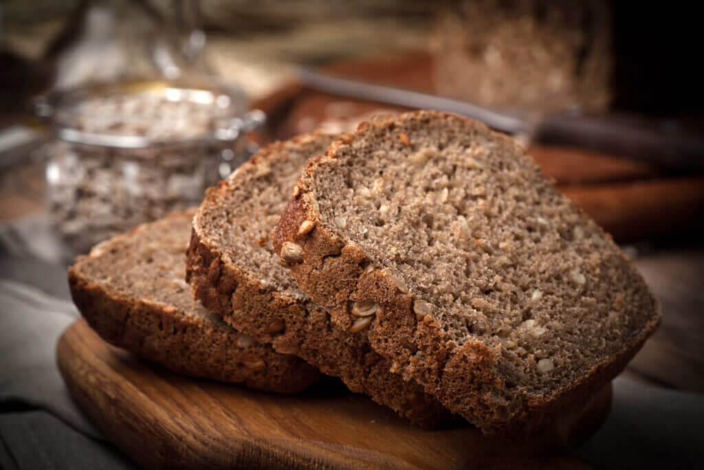 Wholemeal bread with sunflower seeds. Dark light.