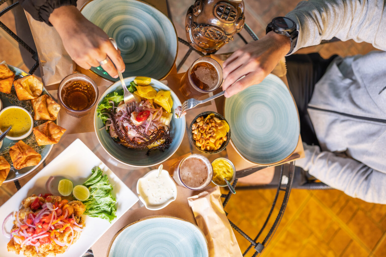 Top view of a table of a restaurant with customers eating peruvian dishes