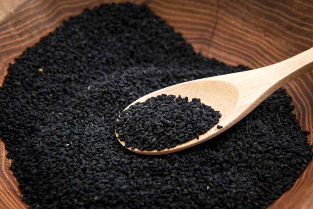 close up of a Nigella sativa herb in a wooden bowl