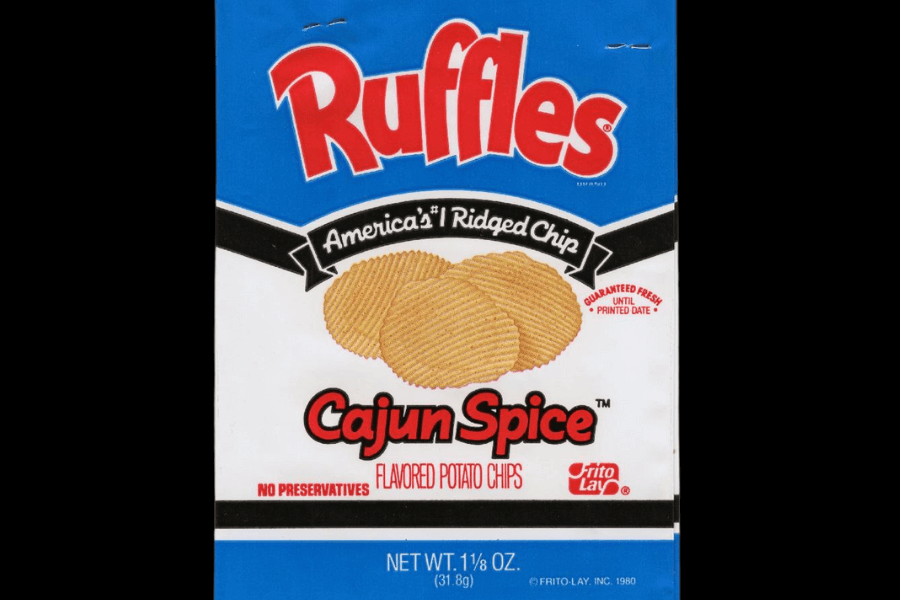 A retro bag of Ruffles potato chips in the "Cajun Spice" flavor with a bold blue and white design. The packaging features an image of ridged chips with the tagline "America's #1 Ridged Chip" and highlights "No Preservatives" at the bottom. The Frito-Lay logo and the "Guaranteed Fresh" seal are also prominently displayed.