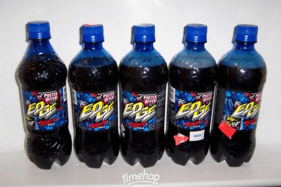 This image shows five bottles of RC Edge Maximum Cola, a soda with bold, colorful branding featuring a comic-style design. The labels advertise a WWF poster offer, tying the drink to wrestling promotions for a dynamic and energetic appeal.