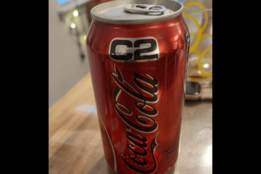 This image shows a can of Coca-Cola C2, a lower-sugar, lower-calorie version of Coca-Cola. The design features the classic red and white branding with the addition of "C2" in bold black and silver at the top.