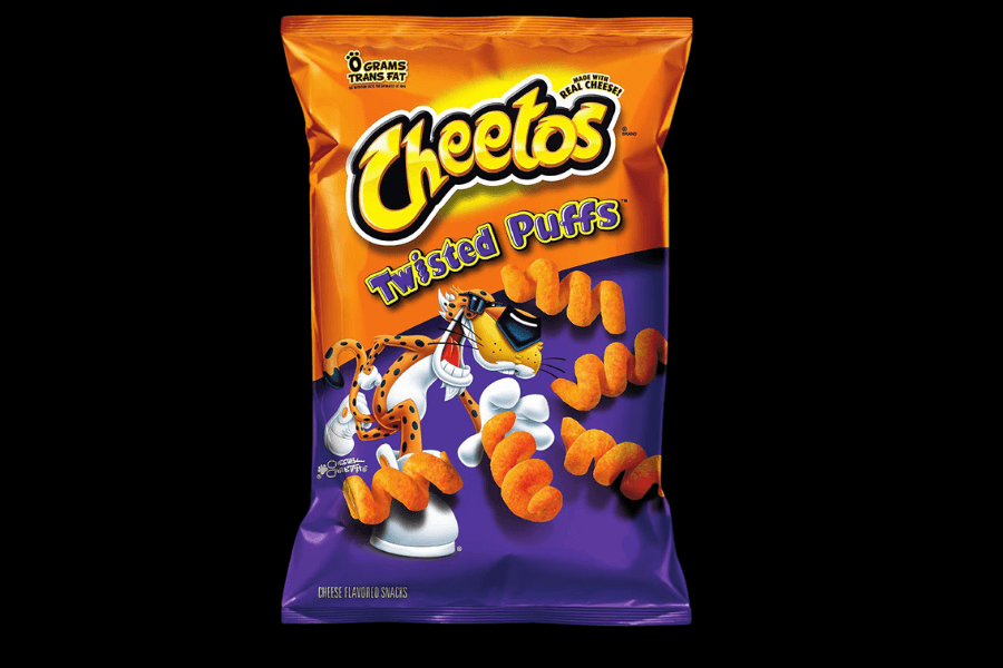 A bag of Cheetos "Twisted Puffs" featuring an orange and purple design. The packaging shows Chester Cheetah wearing sunglasses, interacting with the twisted cheese-flavored puffs, which are scattered around him. The label highlights "Made with Real Cheese" and "0 Grams Trans Fat" at the top.