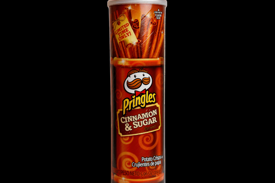 A can of Pringles in the "Cinnamon & Sugar" flavor with a red and orange design featuring cinnamon sticks and sugar swirls. The label highlights "Limited Time Only!" at the top and includes the Pringles mascot with the flavor name in bold lettering. The can is set against a black background.