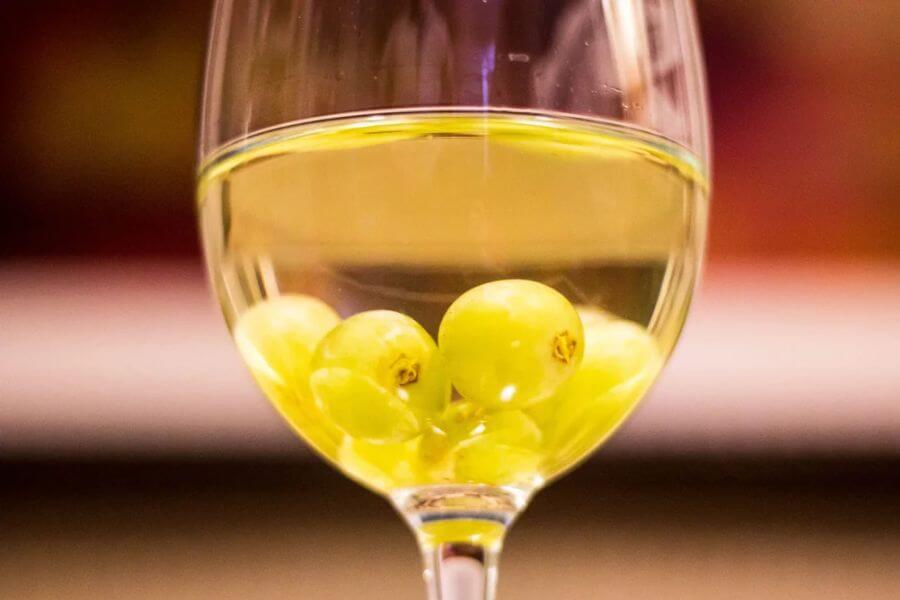 green grapes inside a glass of white wine