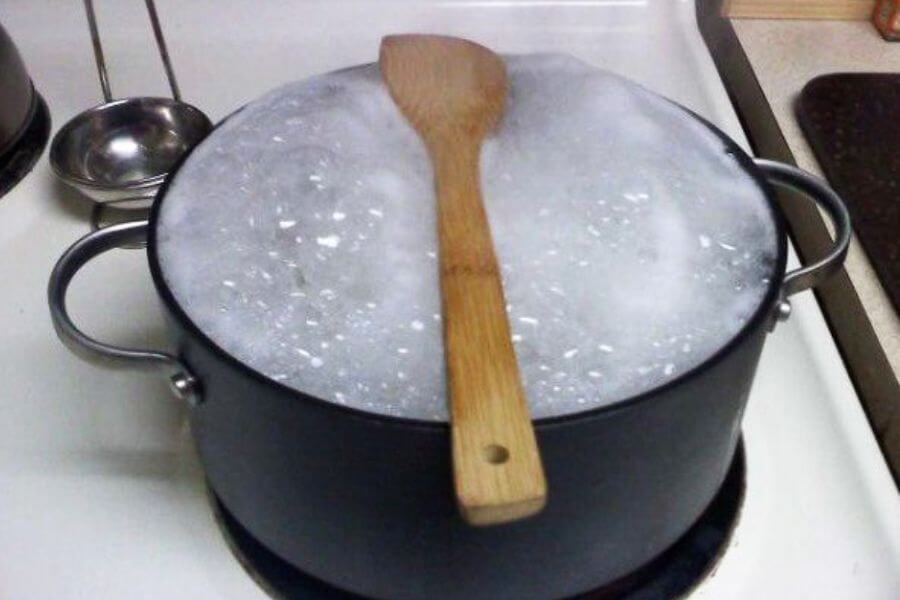 wooden spoon on top of a pot with boiling water