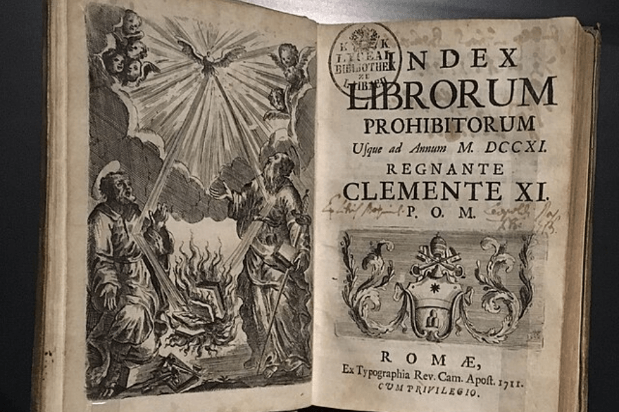 Open antique book titled Index Librorum Prohibitorum, printed in 1711 under Pope Clement XI, featuring a Latin title page on the right and an engraving on the left showing books being burned as a divine dove radiates light from the heavens, surrounded by angels and saints.