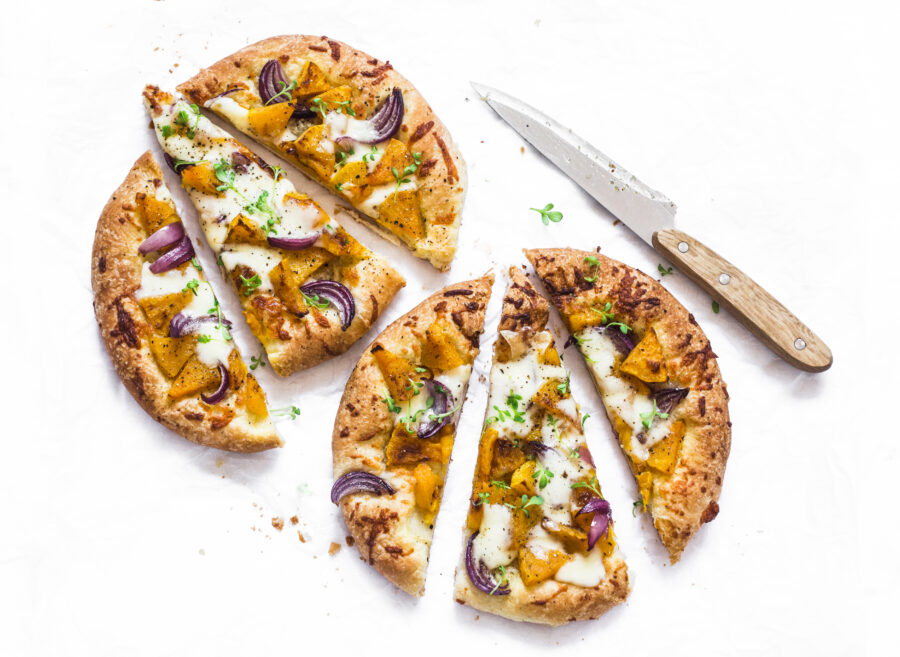 Cheesy autumn veggie flatbread. Pumpkin, sweet potato, red onion, mozzarella pizza on light background, top view