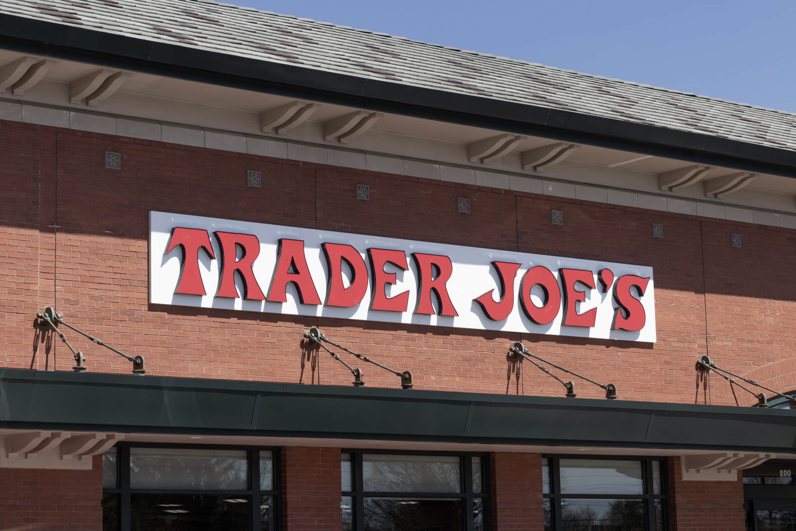 Trader Joe’s storefront sign on a beige building with inset image of French Roast low acid coffee can.