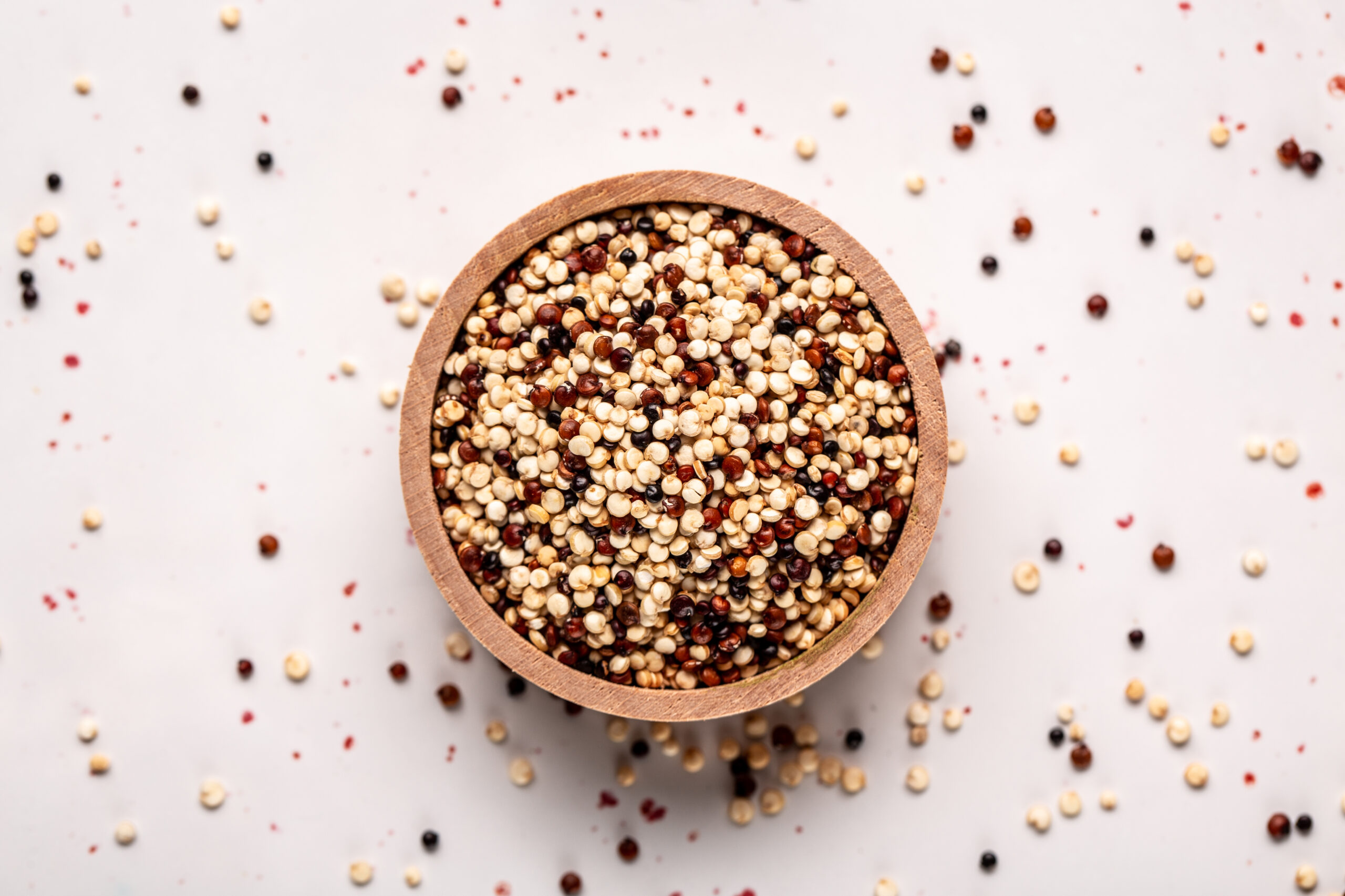 close Set of three varieties of uncooked quinoa on white background, top view.