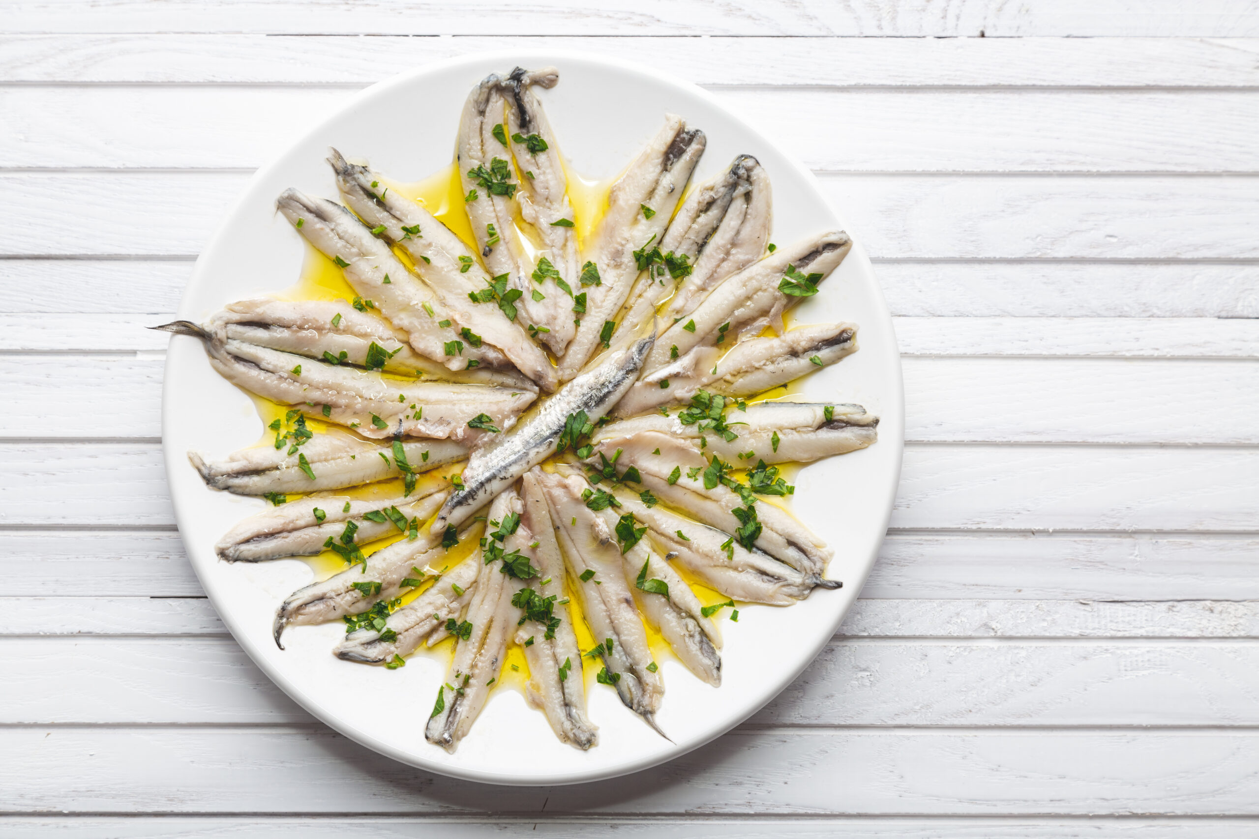 Marinated anchovies in vinegar with olive oil and parsley. Traditional spanish tapa