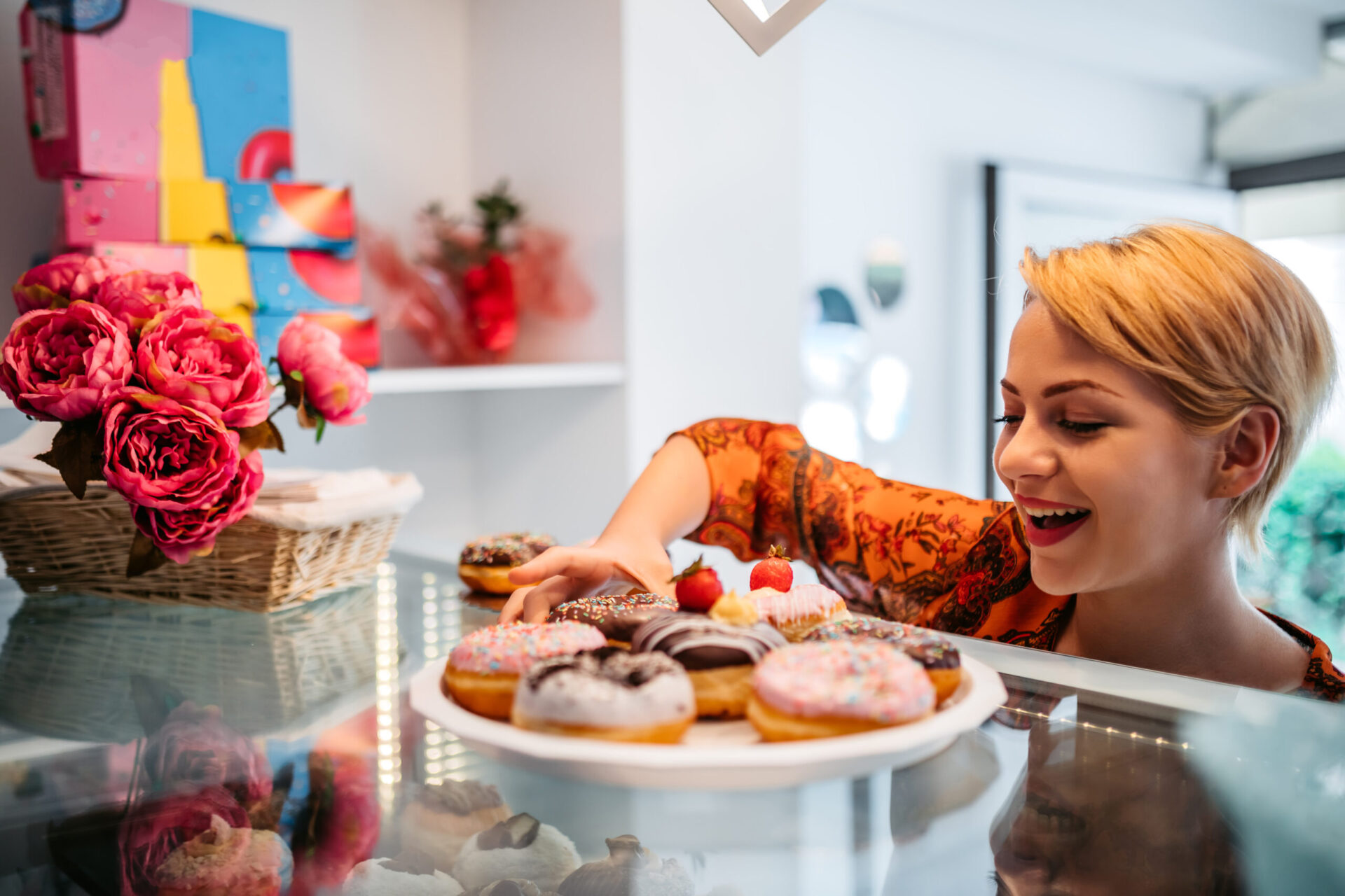 Woman getting a donut from a display platter
