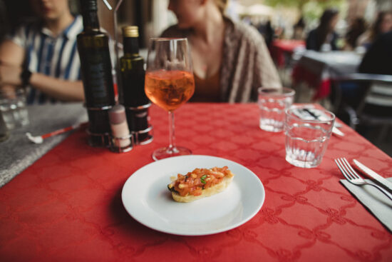 A front view of a plate of bruschetta on a table in a restaurant.