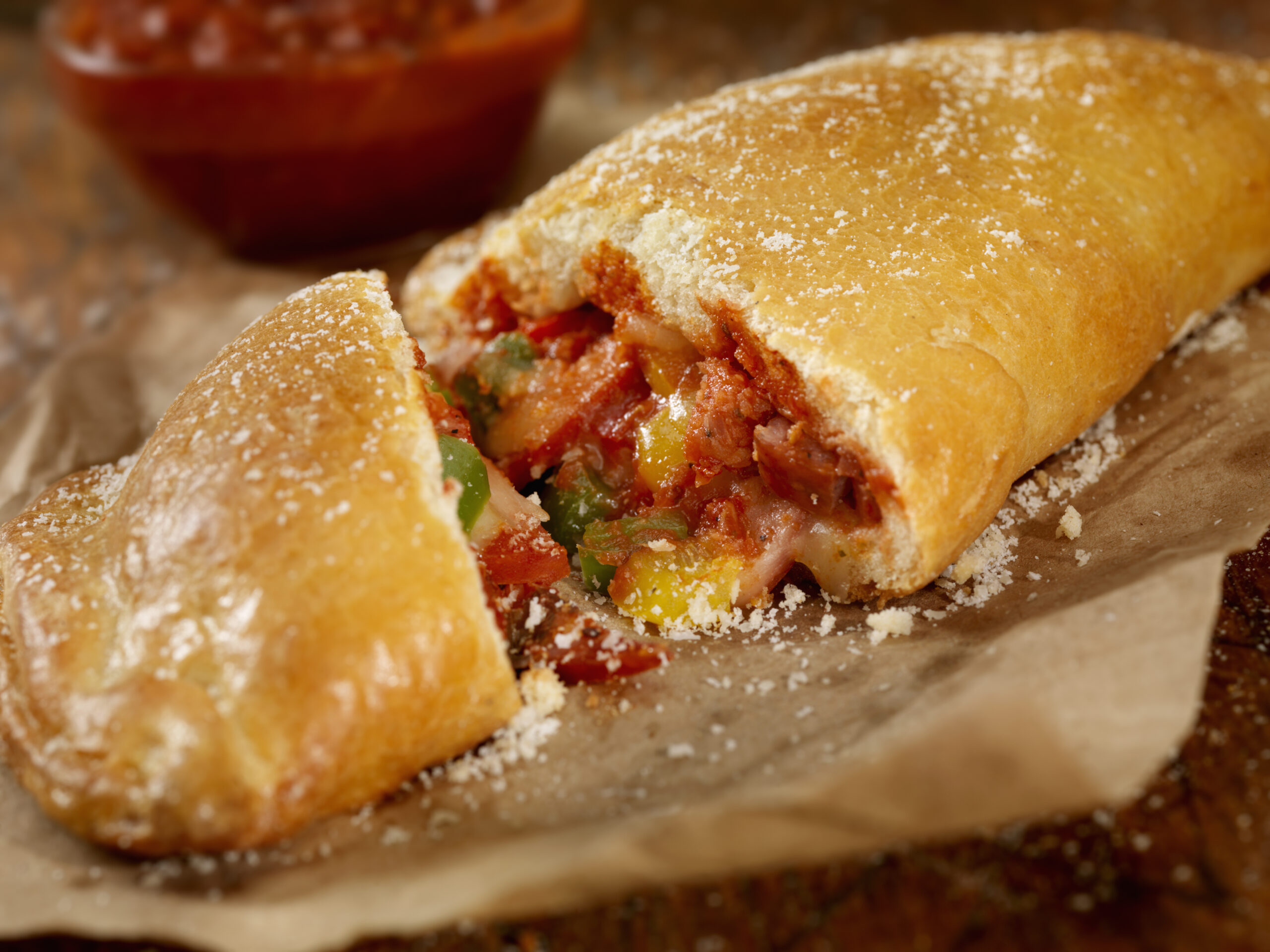 Authentic Hand Made Italian Calzone with Pepperoni, Sausage, Peppers, Fresh Parmesan and Marinara Sauce  - Photographed on a Hasselblad H3D11-39 megapixel Camera System