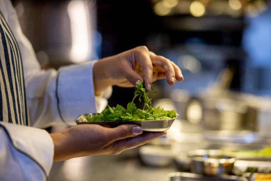 Chef holding some herbs while cooking at a restaurant - commercial kitchen concepts