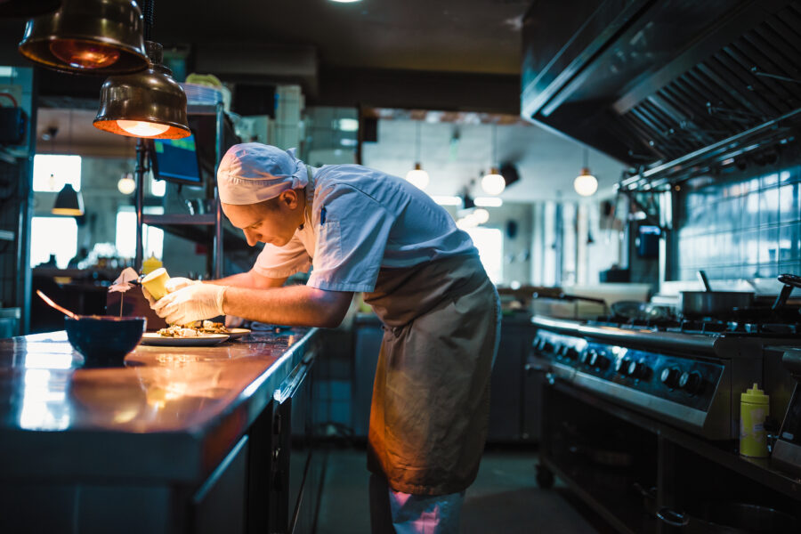 Chef serving food in the modern kitchen in a high-end restaurant