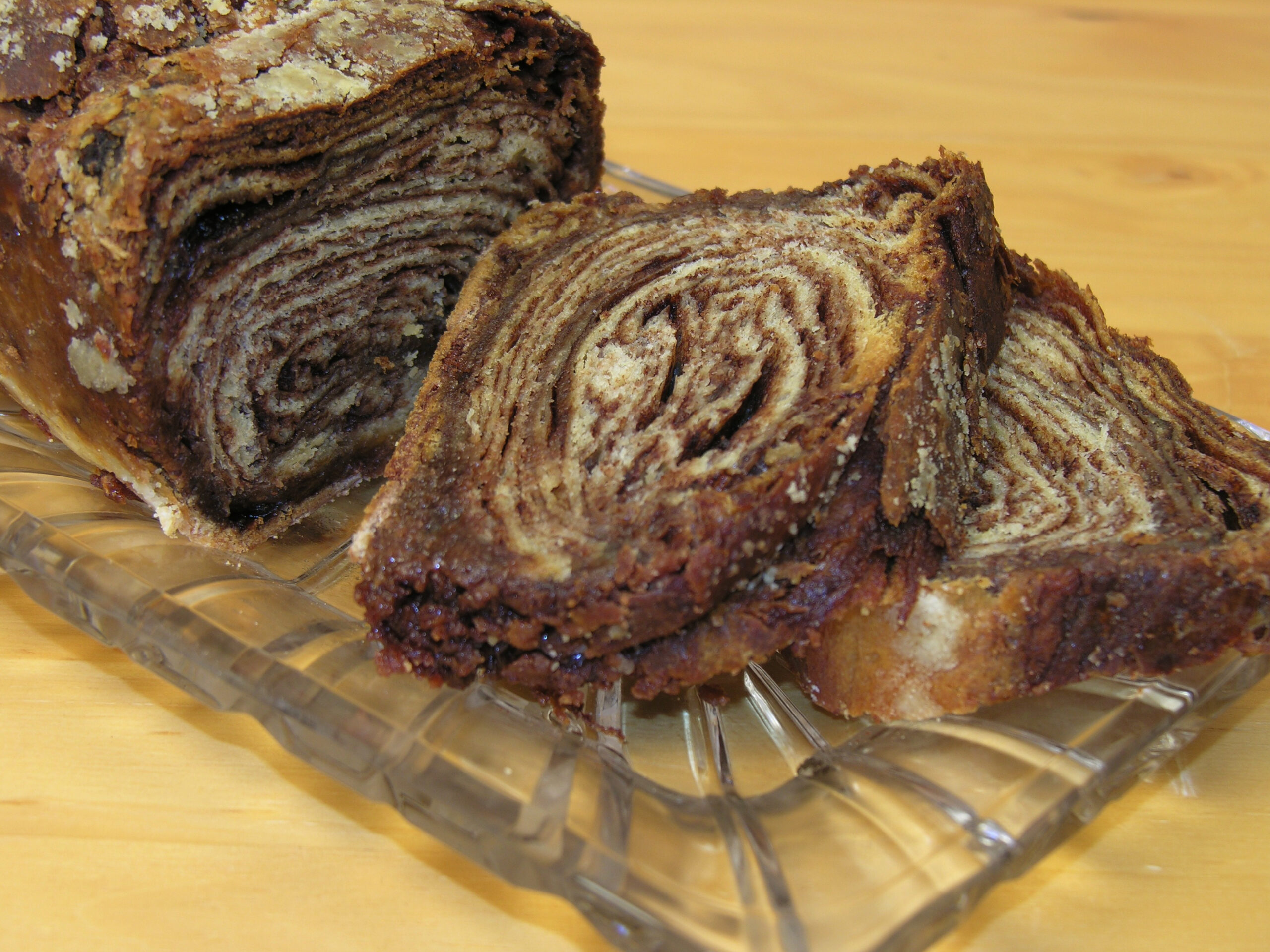 Cinnamon gourmet babka loaf with cut slices on crystal tray