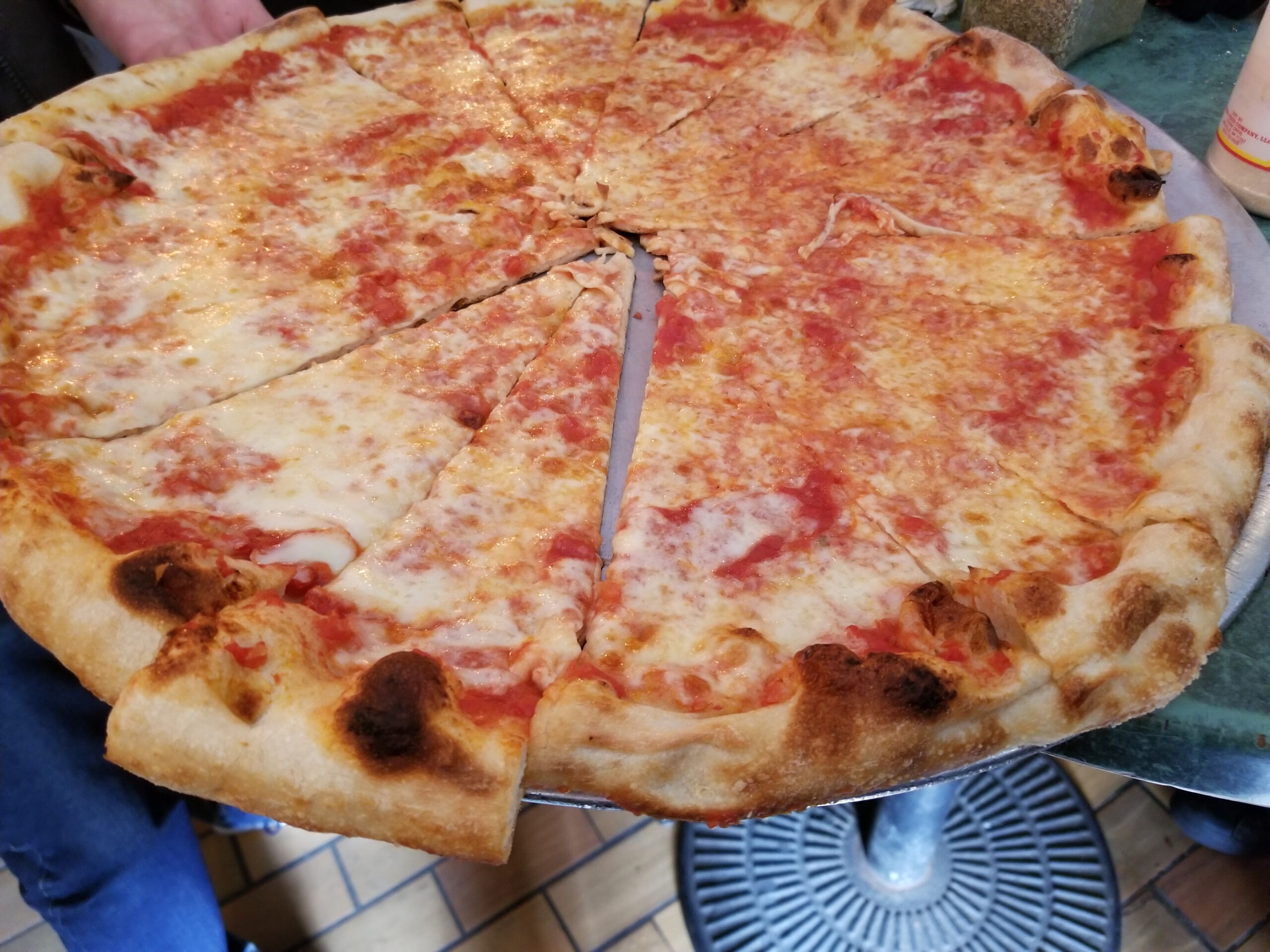 Delicious New York style pizza close-up held up and ready to eat