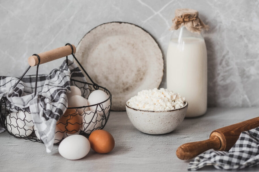 Fresh dairy products, milk, cottage cheese, eggs in stylish ceramic dishes on a gray background. The concept of natural, dietary nutrition. Useful products.