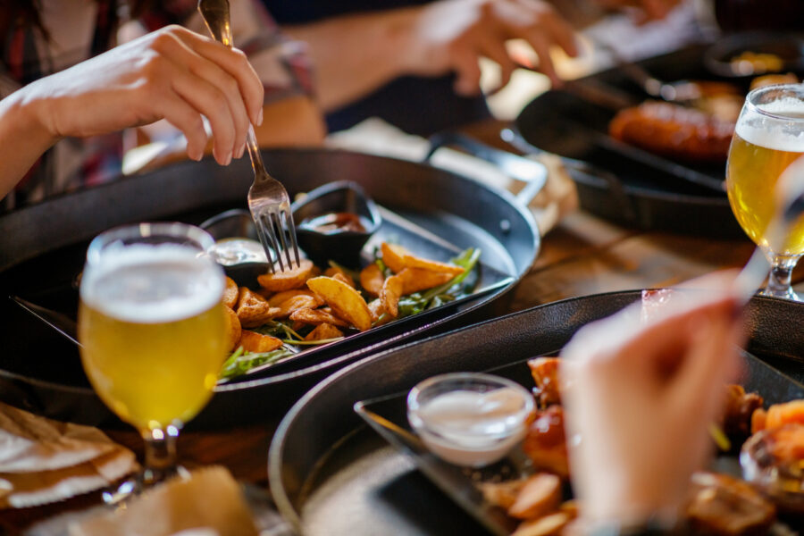 Having fried potaoes and craft beer, sitting at the table in a pub with friends