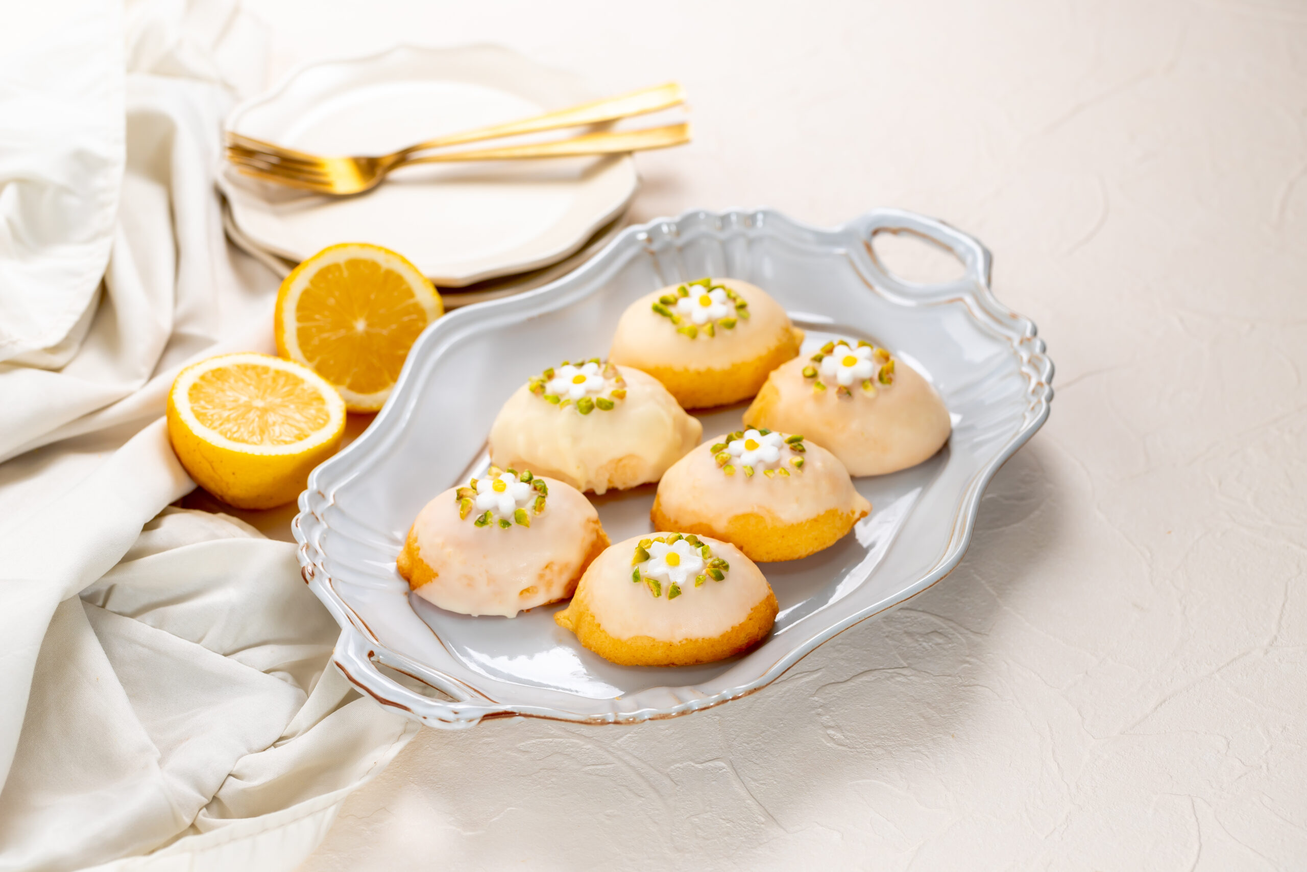 Lemon shaped citrus flavored cake coated with white chocolate and pistachio