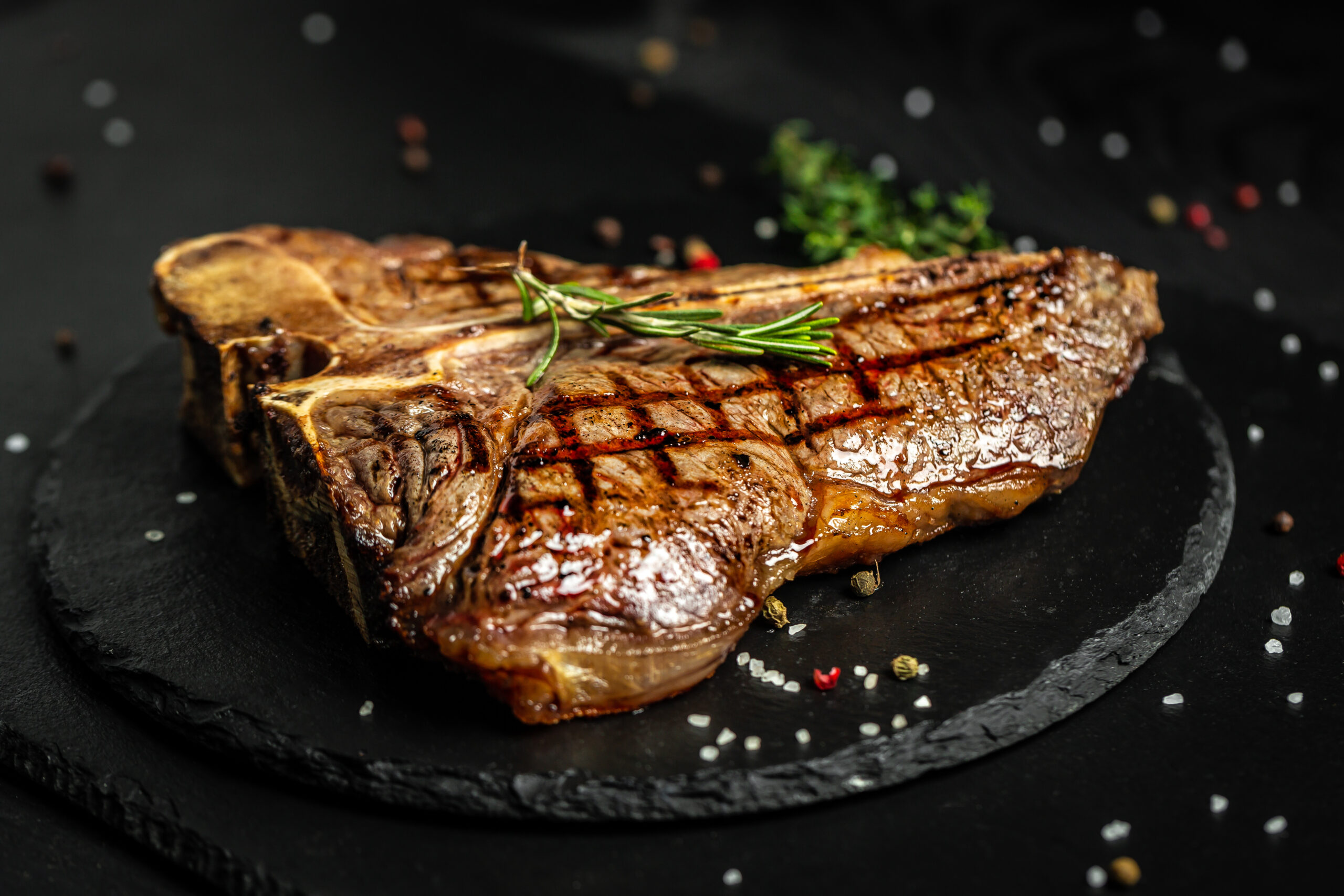 T-bone or aged wagyu porterhouse grilled beef steak with spices and herbs. Medium rare Grilled T-Bone Steak, Barbecue aged wagyu porterhouse. on wood table background asian halal food menu for restaurant