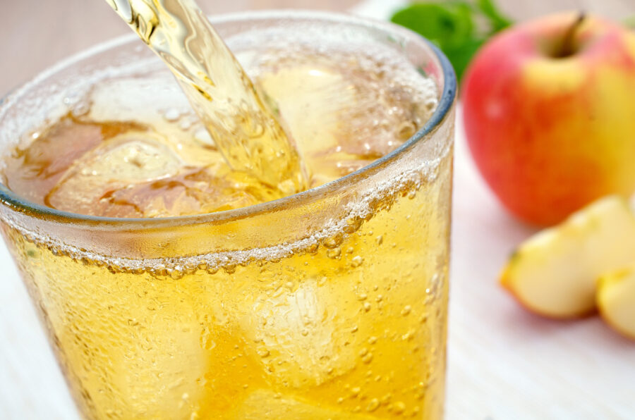 A glass of refreshing ice-cold apple juice spritzer 