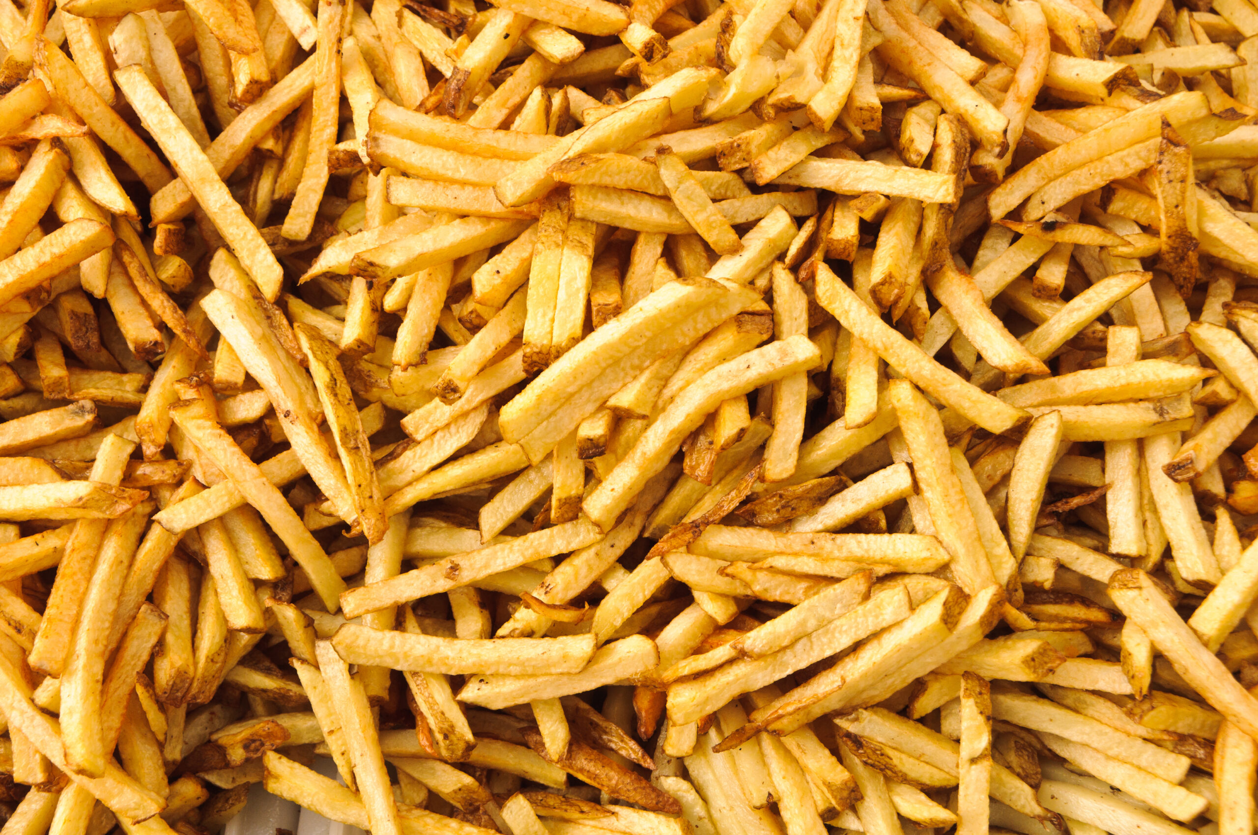 cooked french fries just pulled from the deep fryer.