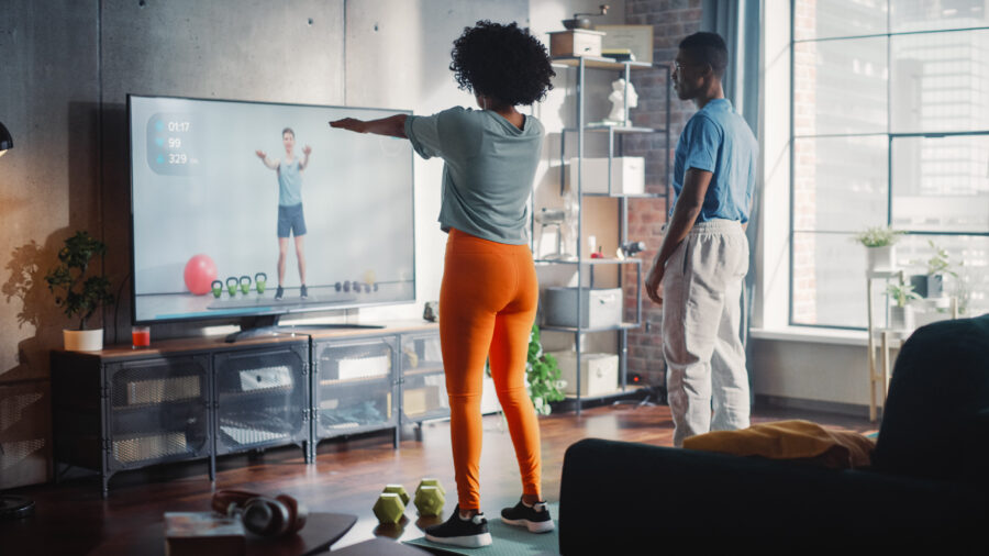 Black Couple Training Together at Home And Watching Tutorial on TV. 