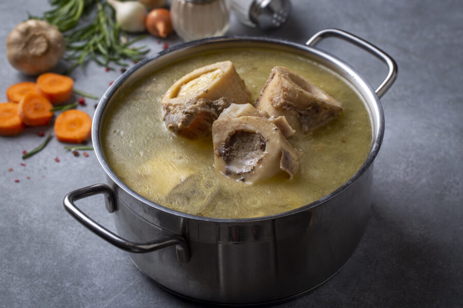 Boiled bone and broth. Homemade beef bone broth is cooked in a pot on. Bones contain collagen, which provides the body with amino acids, which are the building blocks of proteins.