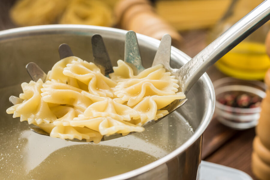 Boiled hot farfalle on the pasta spoon