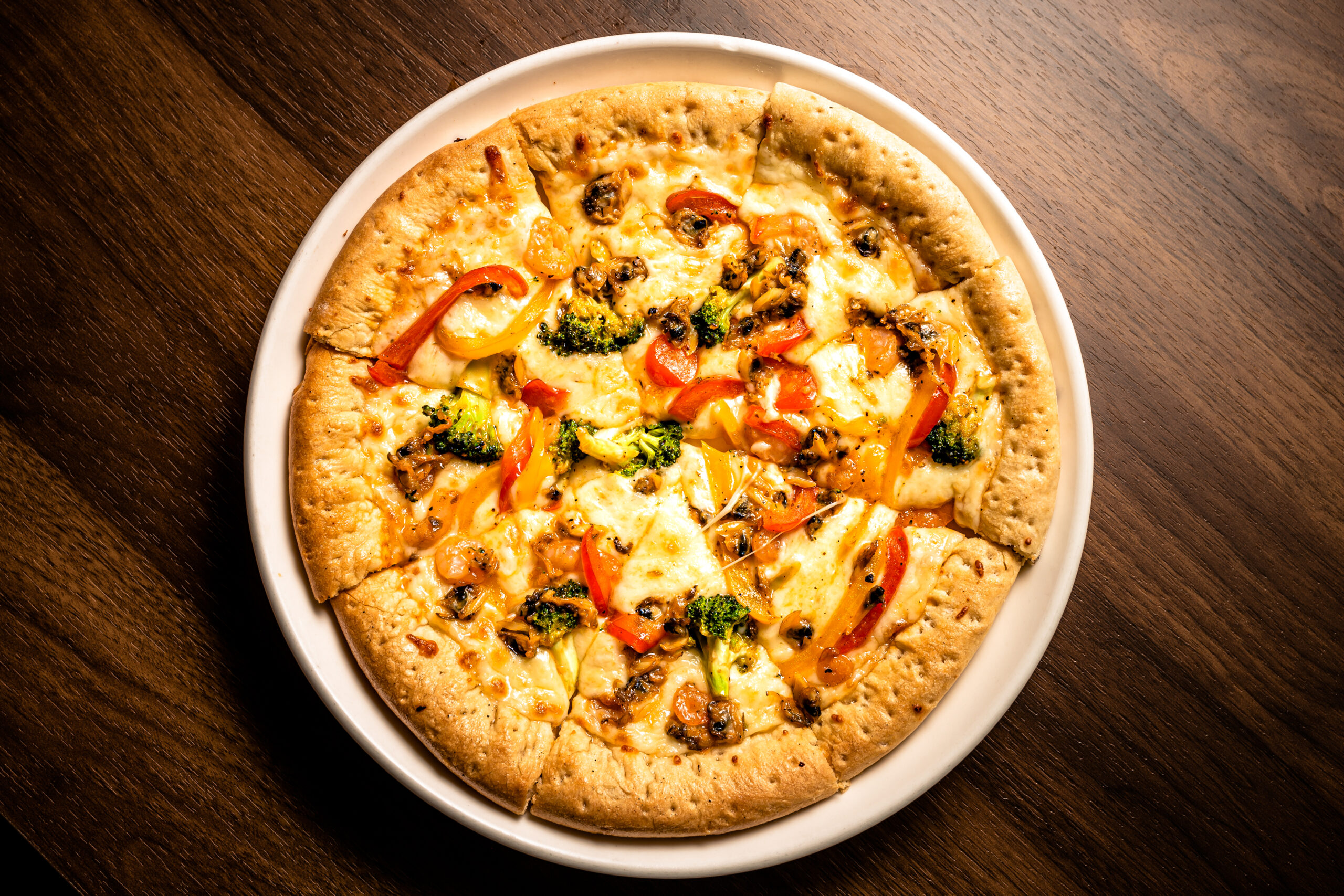 Clam, Shrimp Mozzarella Cheese Pizza Served On A White Ceramic Plate On Wooden Table