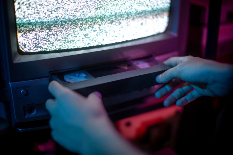 Close up of hands insert vhs into old cathode screen
retrowave and aesthetic vibes