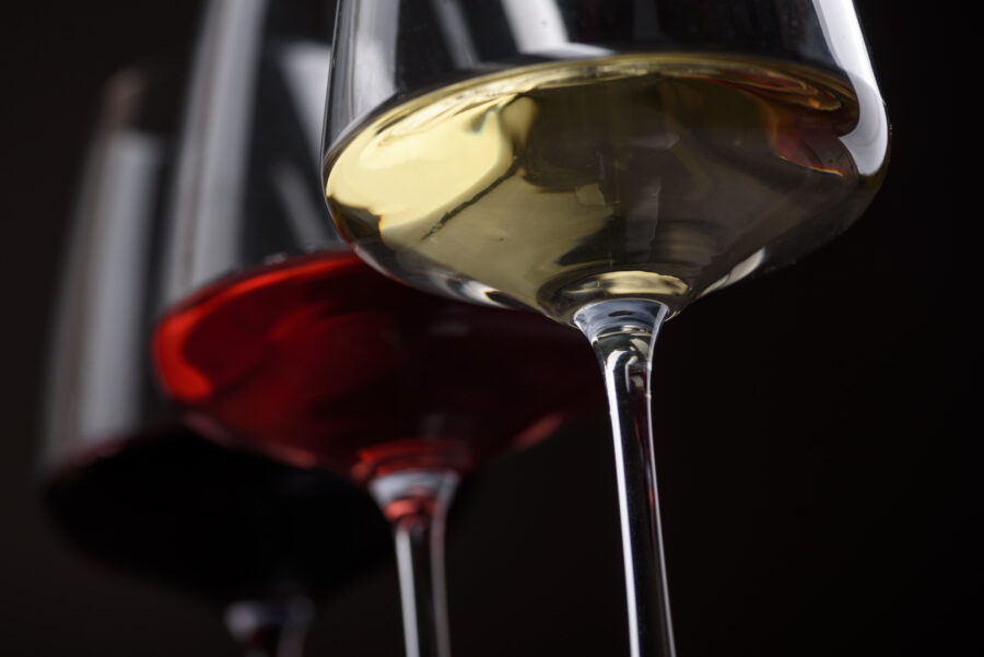 Closeup of three glass of red, rose and white wine over black background.