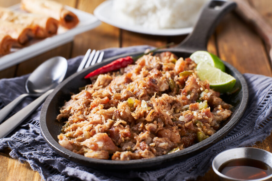 filipino pork sisig in cast iron pan close up