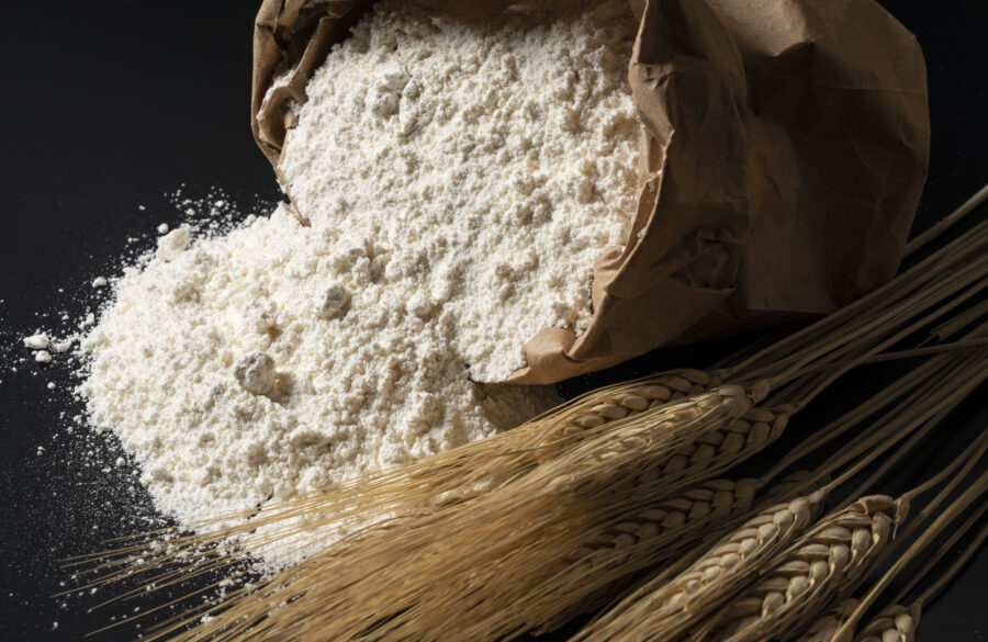 Flour and ears of wheat on a black background. Close-up