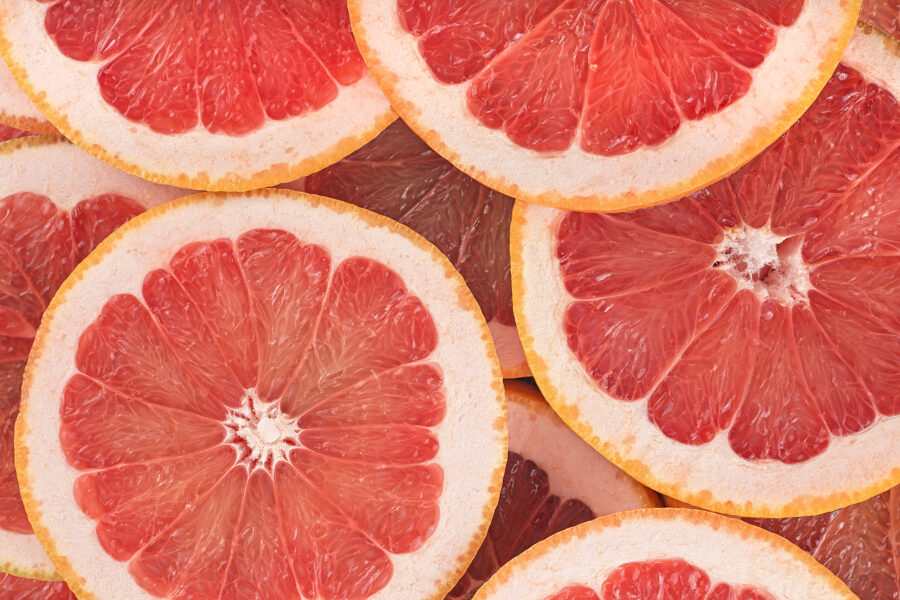 Texture of ripe grapefruit slices, closeup.