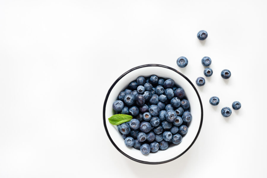 Fresh blueberries in bowl on white background. 