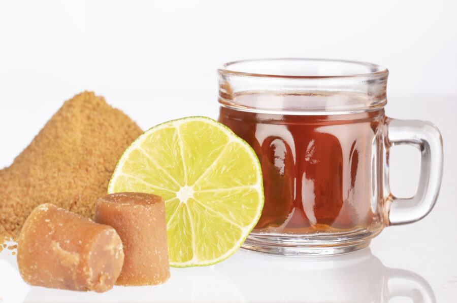 Fresh homemade Aguapanela, Agua de Panela or Aguadulce, a popular Latin American sweet drink made of panela unrefined whole cane sugar boiled in water, served warm or cold with lime