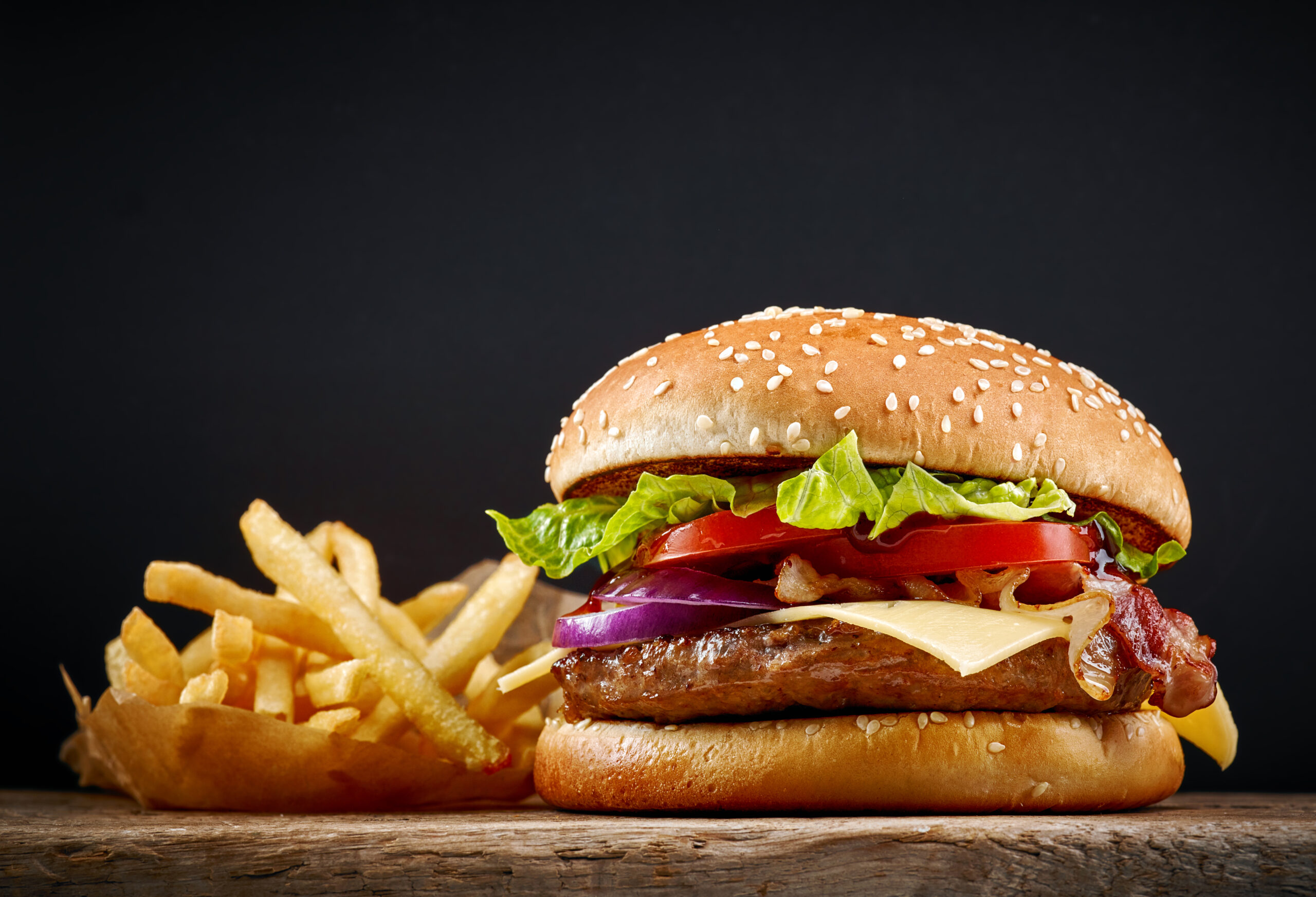 fresh tasty burger and french fries on wooden table